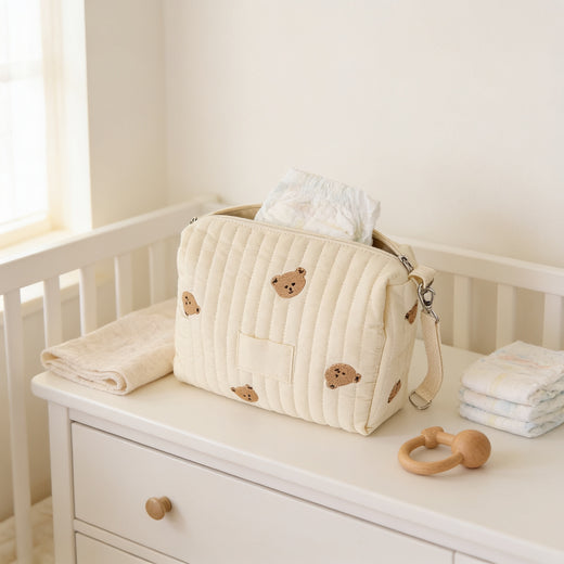 Lumiwee Posy embroidered diaper pouch: cream quilted bear pouch on a nursery dresser with diapers