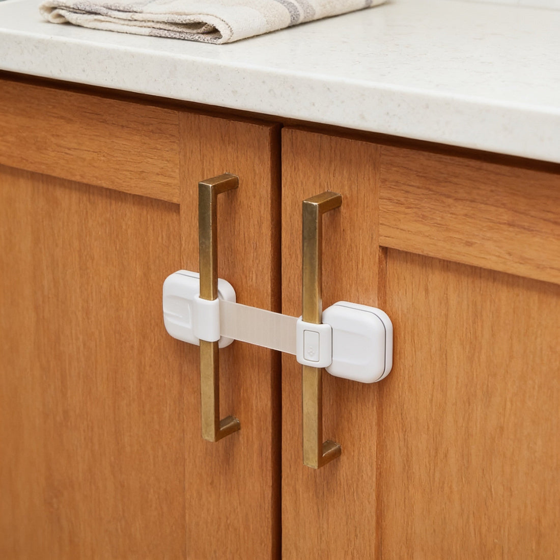 White adhesive strap lock across two oak cabinet doors