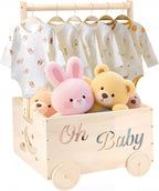 Wooden toy box crate on four wheels holding a pink bunny and teddy bears, with baby outfits hanging on the rail above
