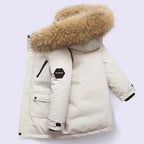 Boys winter coat with hood in cream, side view showing the fluffy hood trim, flap pocket and sleeve patch