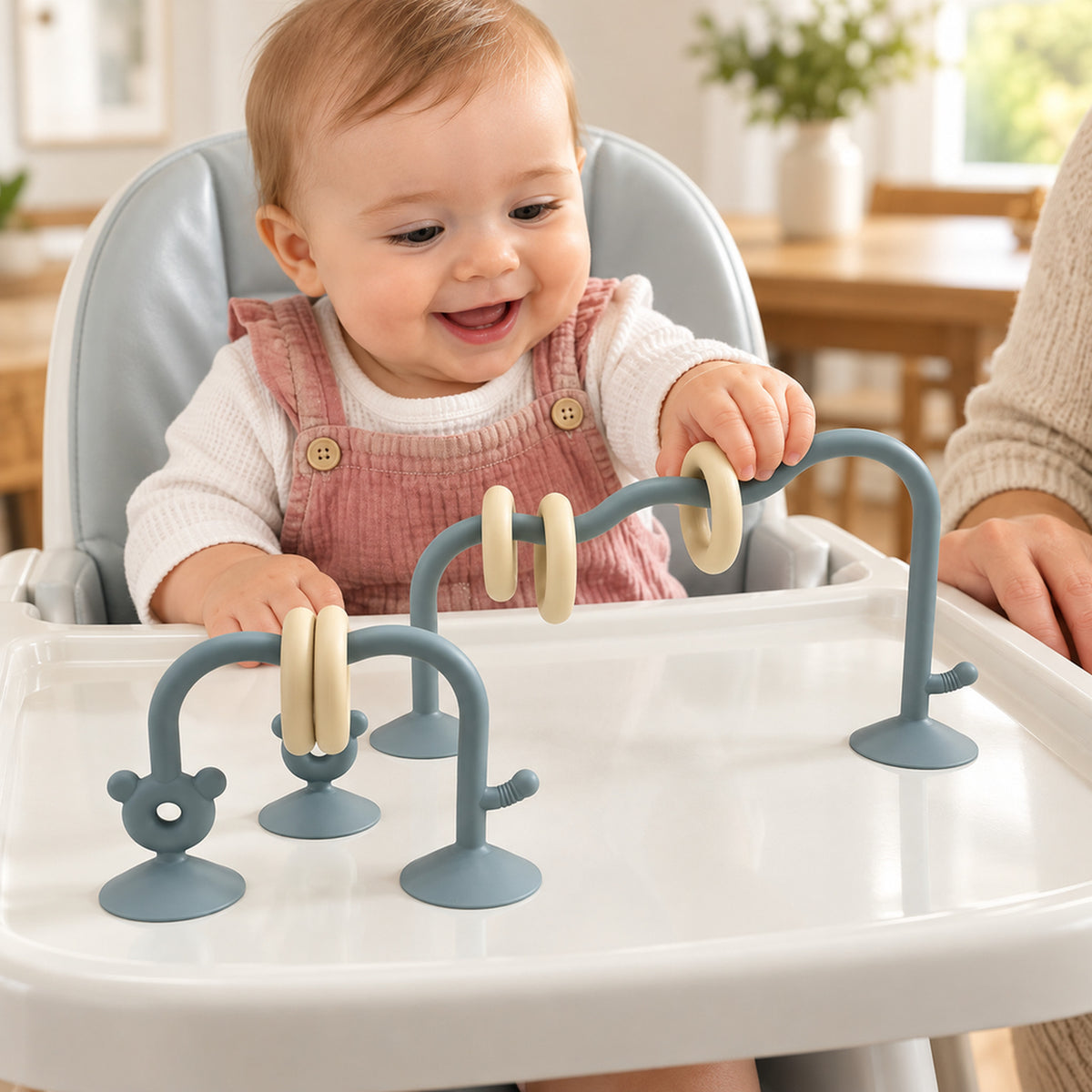 Lumiwee Abacus Suction Cup Toy for High Chairs: baby sliding a ring on the sea blue suction-cup abacus toy with an adult nearby
