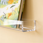 Lumiwee Aspen wall-mounted picture book shelf: close-up of the clear face-out trough