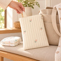 Lumiwee Bloom Quilted Embroidered Diaper Pouch: adult hand lifting the Tulip quilted diaper pouch beside a diaper tote