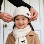 Lumiwee Bow knit kids hat and scarf set: pulling the beanie cuff down over a child ears