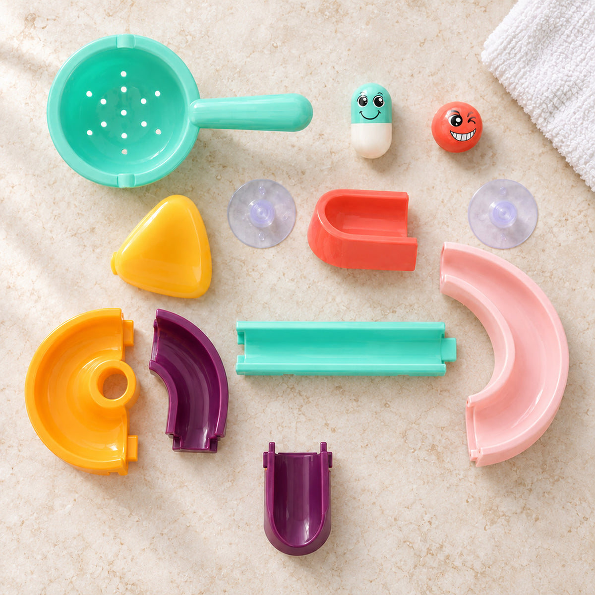 Lumiwee Cascade Water Track Bath Toy Set: twelve included track, play and mounting pieces arranged on a counter