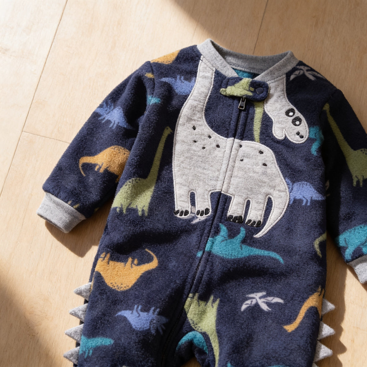 Lumiwee Critter fleece baby romper: close-up of the fleece, dinosaur applique and leg spikes