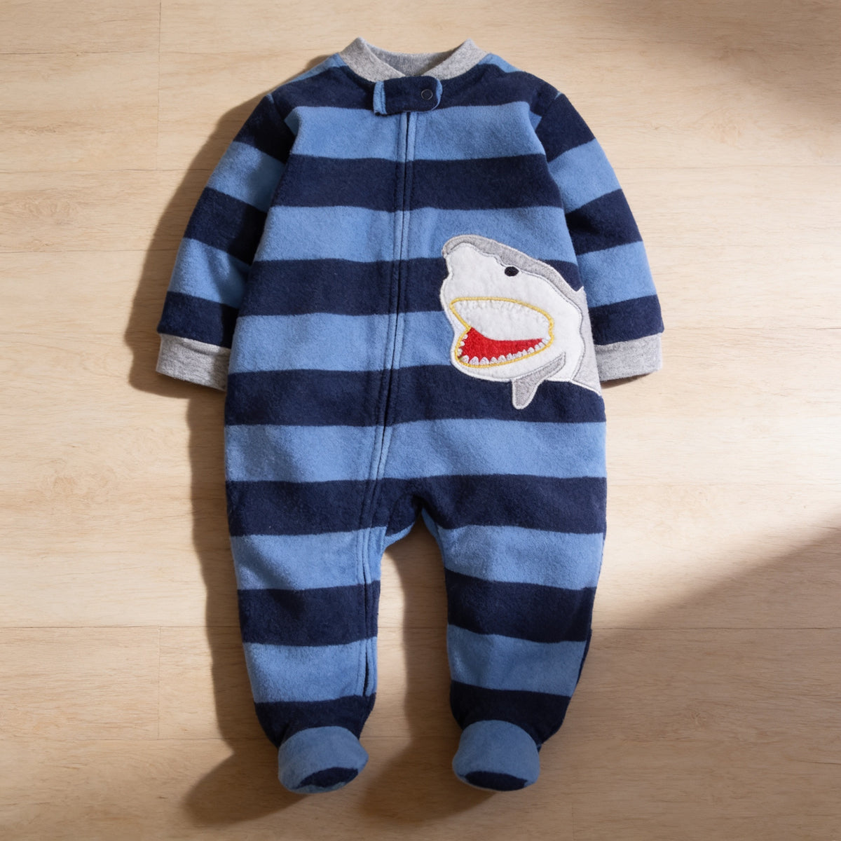 Lumiwee Critter fleece baby romper, Blue Stripe Shark option, in a bright room
