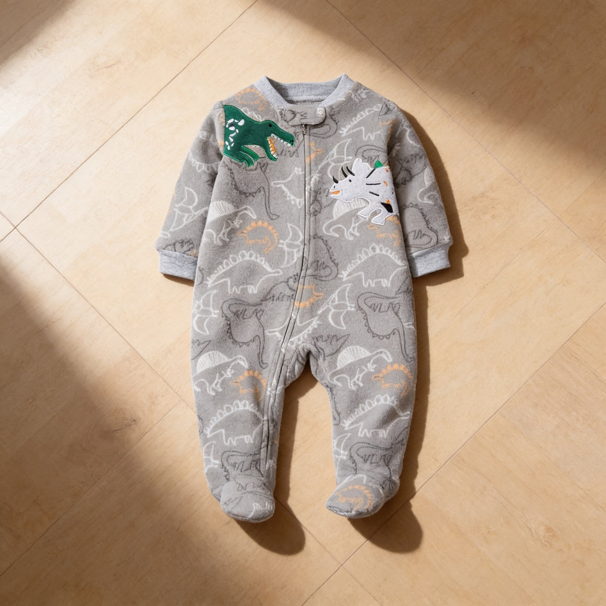 Lumiwee Critter fleece baby romper, Gray Dino option, in a bright room
