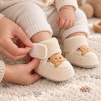Adult fastening the wraparound strap on a Lumiwee Brown Bear baby bootie