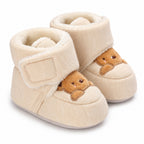 Pair of cream Lumiwee Brown Bear baby booties on a white background