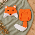 Lumiwee orange fox crochet hat and diaper cover with white-tipped tail on a sage blanket