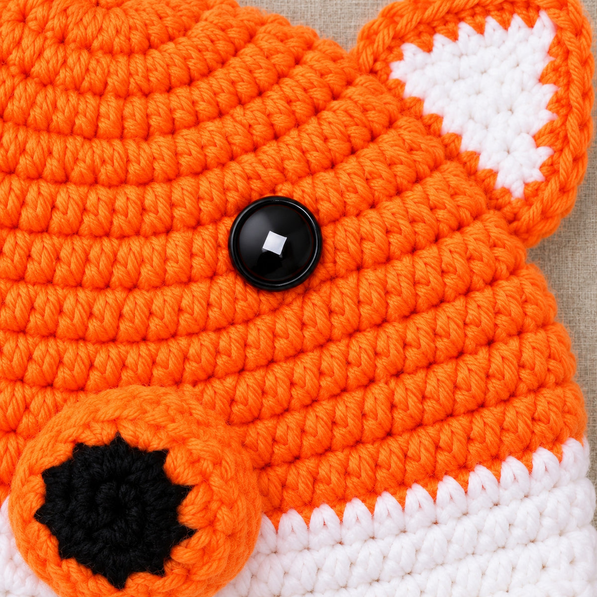 Close-up of the fox hat crochet stitches, button eyes and ear