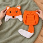 Adult arranging the fox crochet hat and diaper cover for a photo session