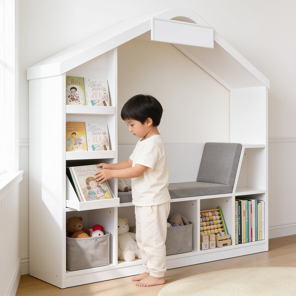 Lumiwee Hazel white kids bookcase with reading nook: child putting a picture book back on a face-out tier
