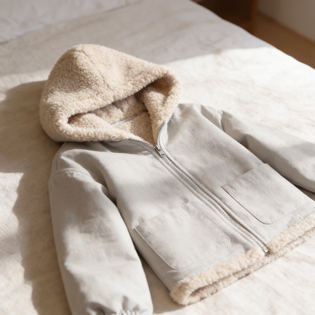 Lumiwee Hearth babywearing maternity jacket: close-up of the sherpa-lined hood, zipper and pocket