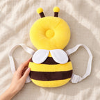 Bee cushion backpack beside an adult hand for scale