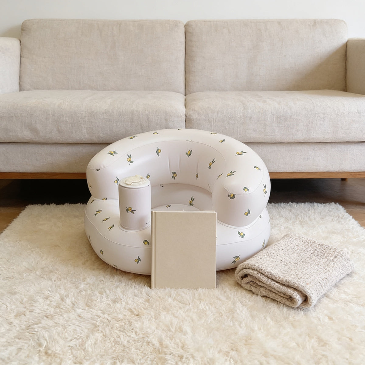 Lumiwee Mallow inflatable baby floor seat: inflatable seat next to a board book for scale