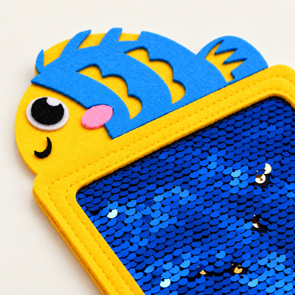 Close-up of blue flip sequins and stitched yellow felt rim on the fish texture mat