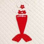 Lumiwee red crochet mermaid tail with matching starfish headband and chest accessory on an ivory quilt