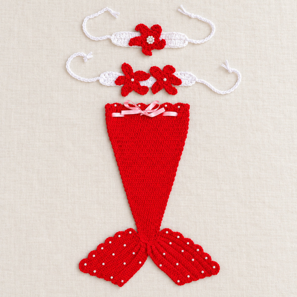 Red mermaid tail and two matching accessories laid separately