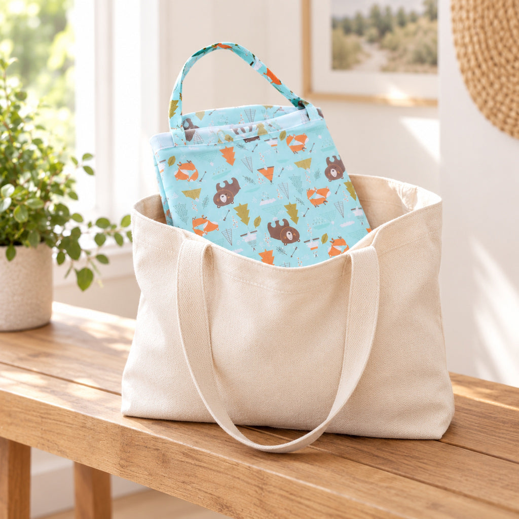 Bear-print nursing cover folded in a cream travel tote