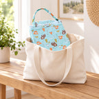 Bear-print nursing cover folded in a cream travel tote