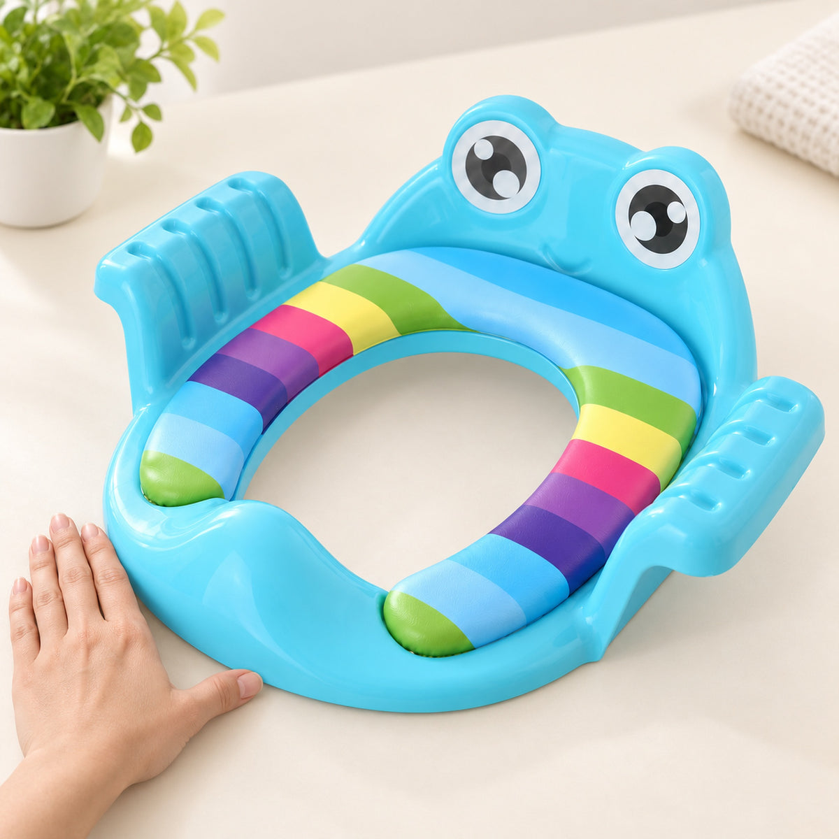 Single blue padded training seat beside an adult hand for scale
