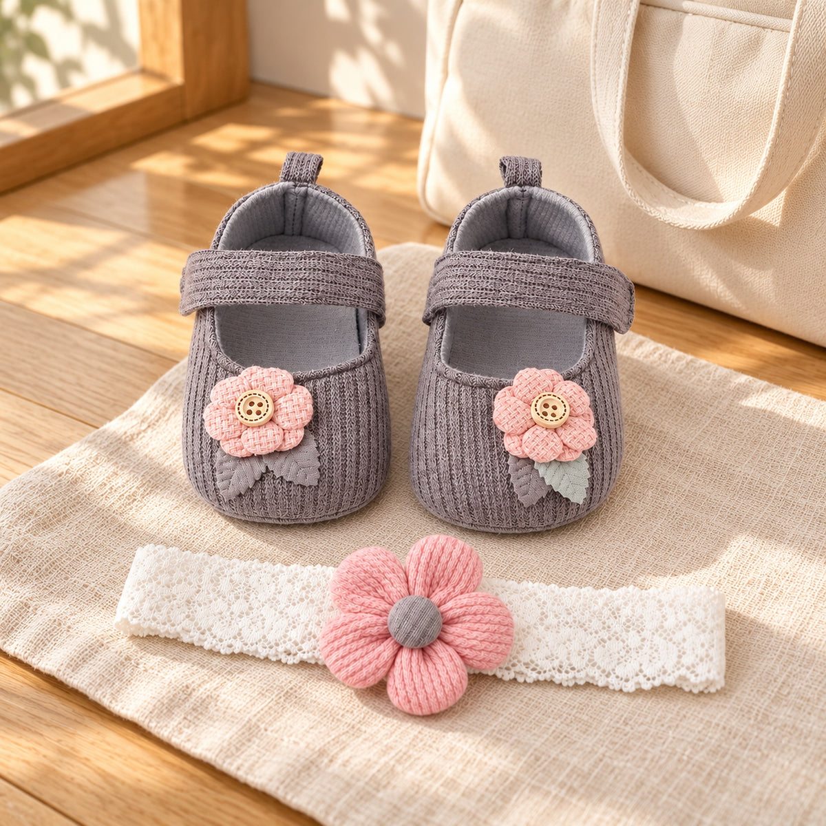 Gray button-flower shoes and matching headband beside a travel tote
