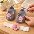 Adult opening a gray baby shoe's hook-and-loop strap