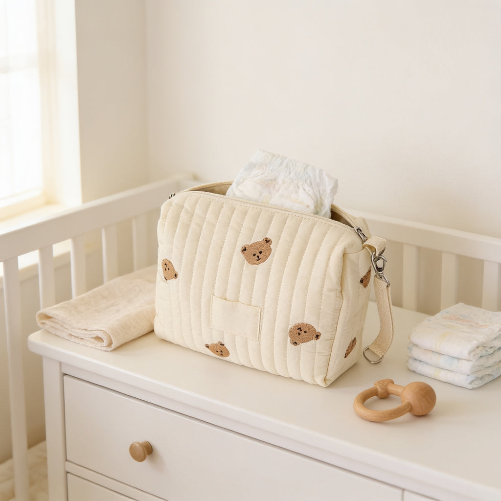 Lumiwee Posy embroidered diaper pouch: cream quilted bear pouch on a nursery dresser with diapers