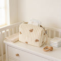 Lumiwee Posy embroidered diaper pouch: cream quilted bear pouch on a nursery dresser with diapers