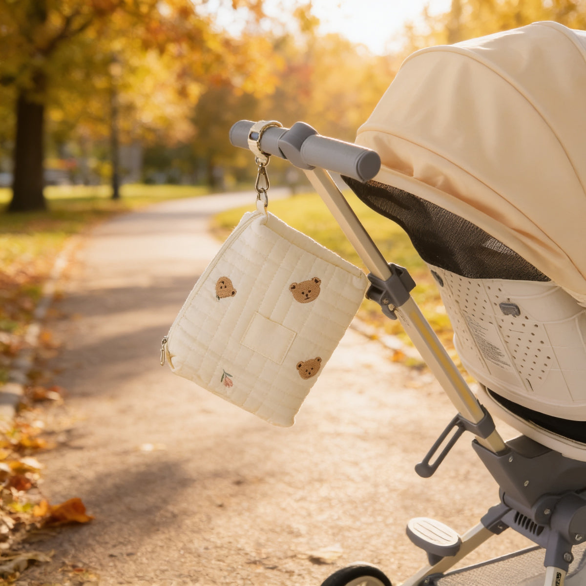 Lumiwee Posy embroidered diaper pouch: bear pouch clipped to a stroller handle in the park