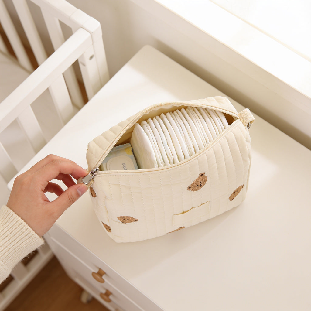 Lumiwee Posy embroidered diaper pouch: unzipping the pouch to show folded diapers inside