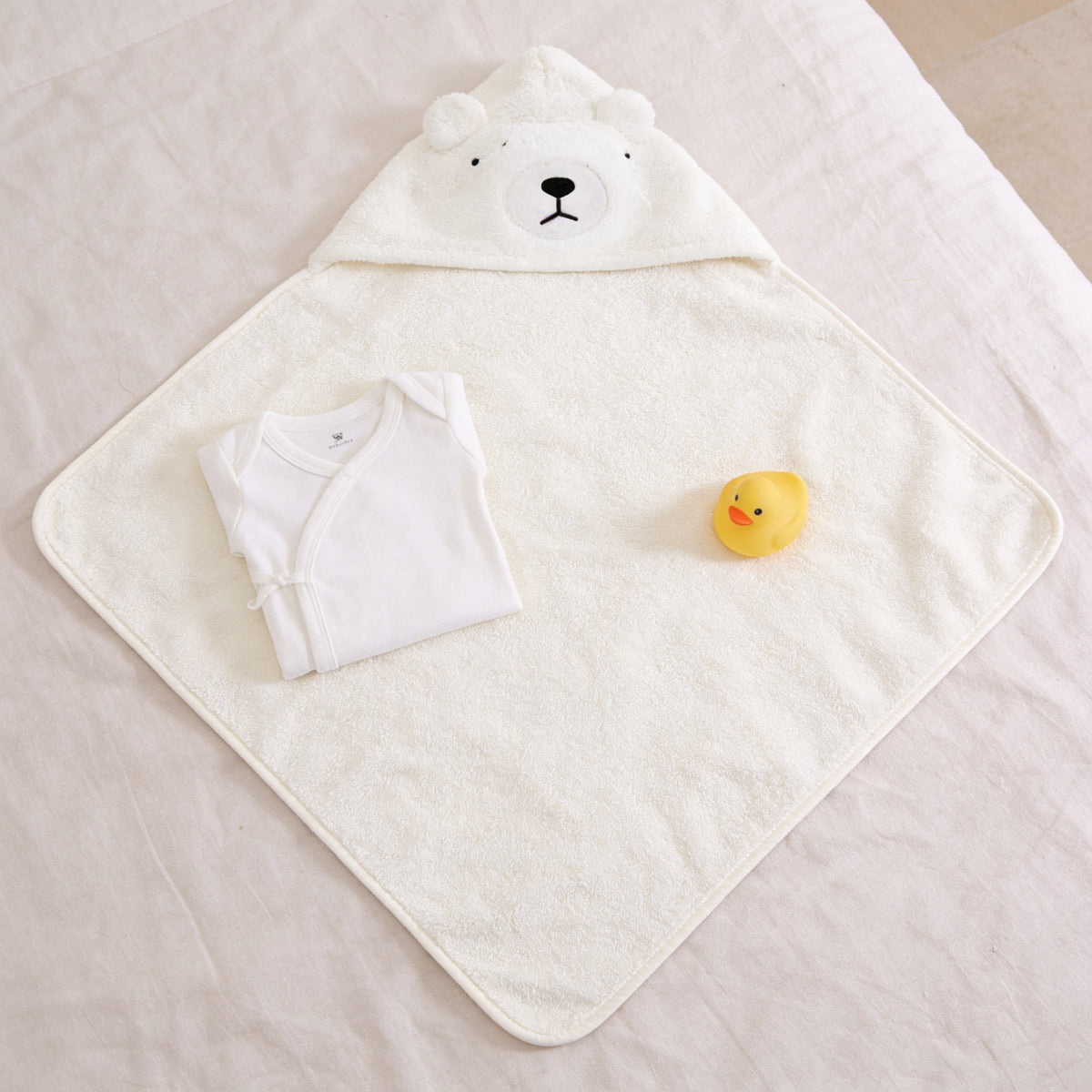 Lumiwee Puddle hooded baby bath towel: the towel laid open with a onesie for scale