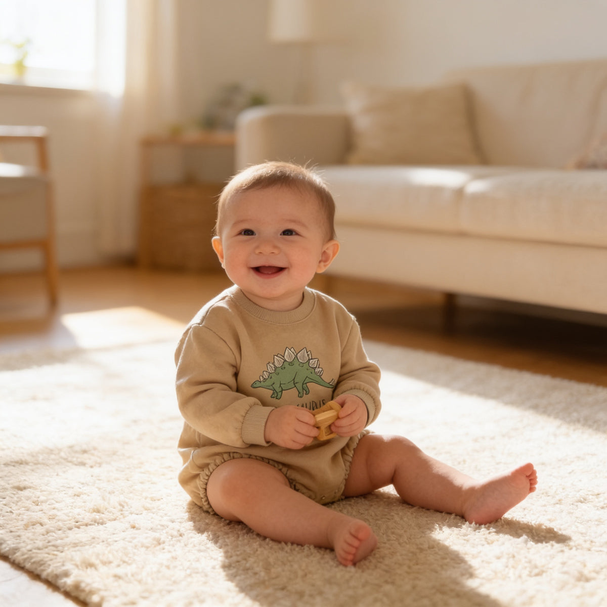 Lumiwee Rex dinosaur baby bodysuit: smiling baby in the stegosaurus bubble romper on a rug
