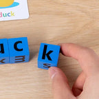 Lumiwee Scribble small letter block held between adult fingers for scale