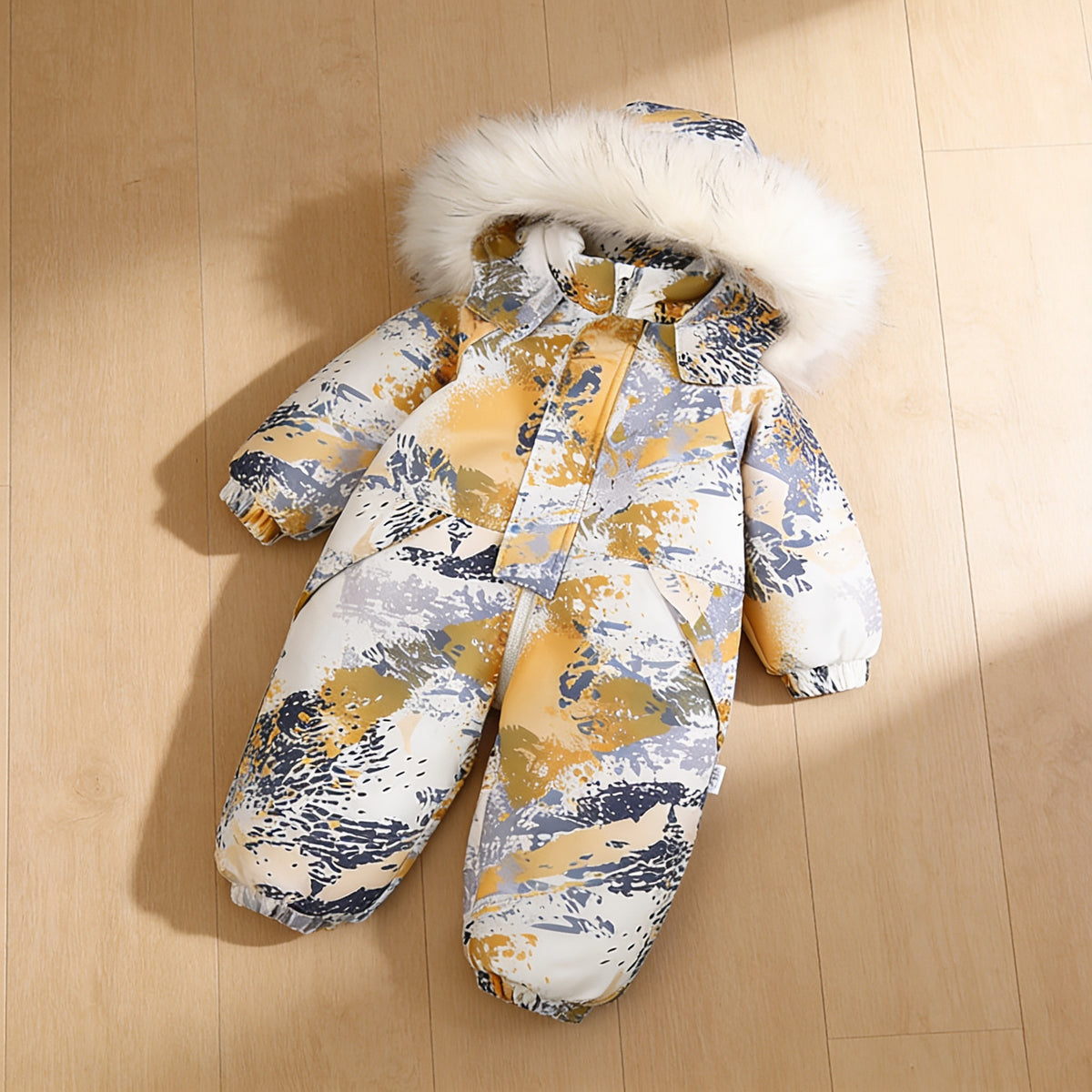 Lumiwee Snowdrop toddler hooded snowsuit: the painted waves snowsuit laid flat on a wood floor