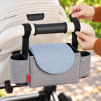 Adult securing a Sparrow hook-and-loop strap around a stroller handlebar