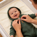 Lumiwee Sprig hooded zip baby romper: zipping the romper up on a smiling baby