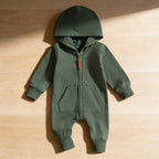 Lumiwee Sprig hooded zip baby romper: the green hooded romper laid flat on a wood floor