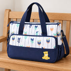 Deep Blue Starling bag with shoulder strap on an oak bench
