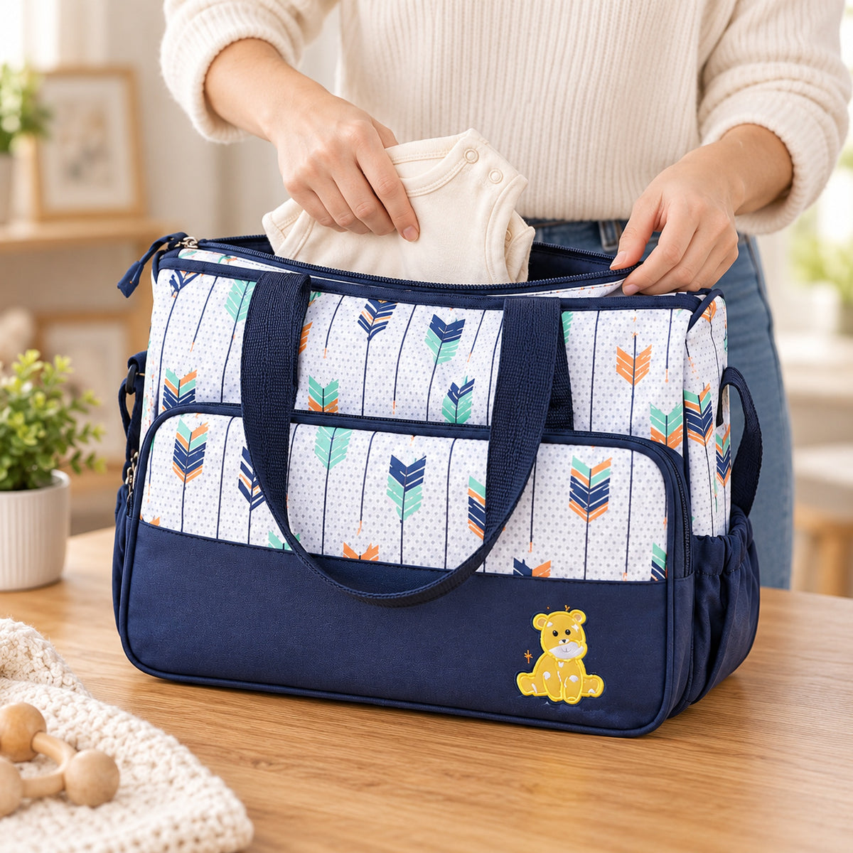 Adult packing a folded cream outfit into the large Starling tote