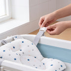 Lumiwee Starry baby bath support mat: clipping a strap over the tub edge