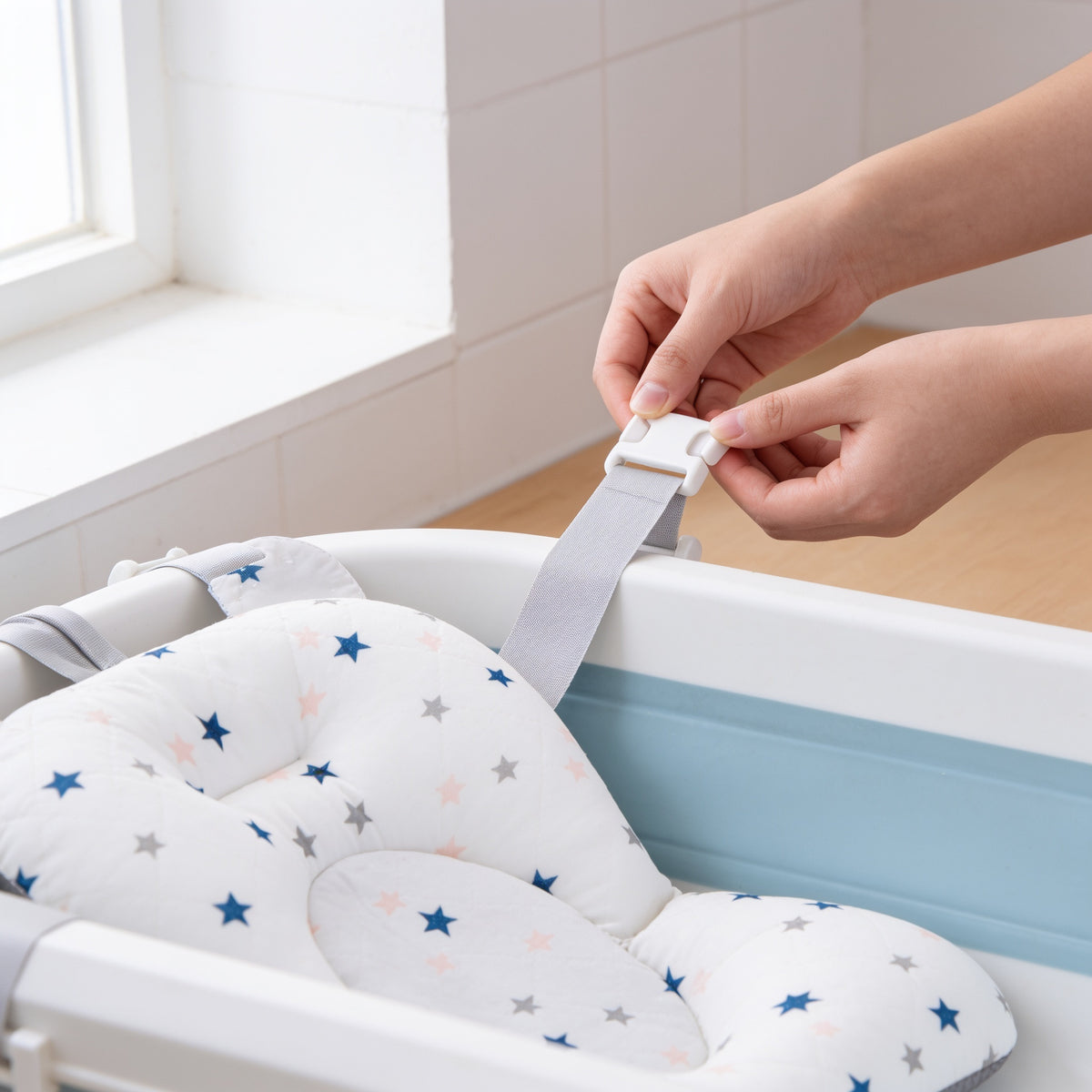 Lumiwee Starry baby bath support mat: clipping a strap over the tub edge