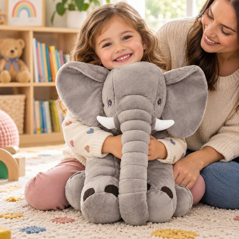 Awake child hugging the gray Stomp elephant on the playroom floor beside a parent