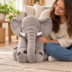 Gray Stomp elephant seated beside an adult for scale