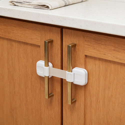 Lumiwee Adhesive cabinet and drawer strap lock: white strap lock across two oak cabinet doors