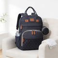 Lumiwee Swift diaper backpack: navy quilted diaper backpack on a linen armchair