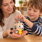 Adult holding a palm-size Tinker cube while a supervised child turns the tap