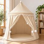 Beige castle tent showing fabric seams, white pom-pom trim and tied-back curtains